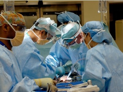A lot of doctors operating on a patient surgically