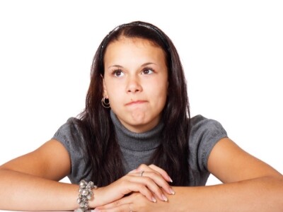 woman on gray with black hair thinking on a white bg