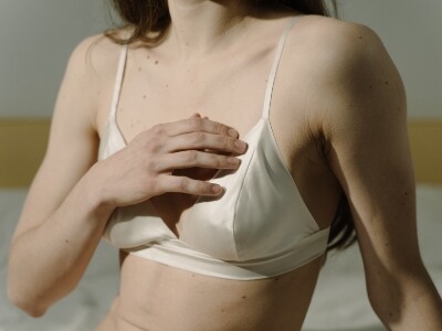 woman on white bra holding her own chest